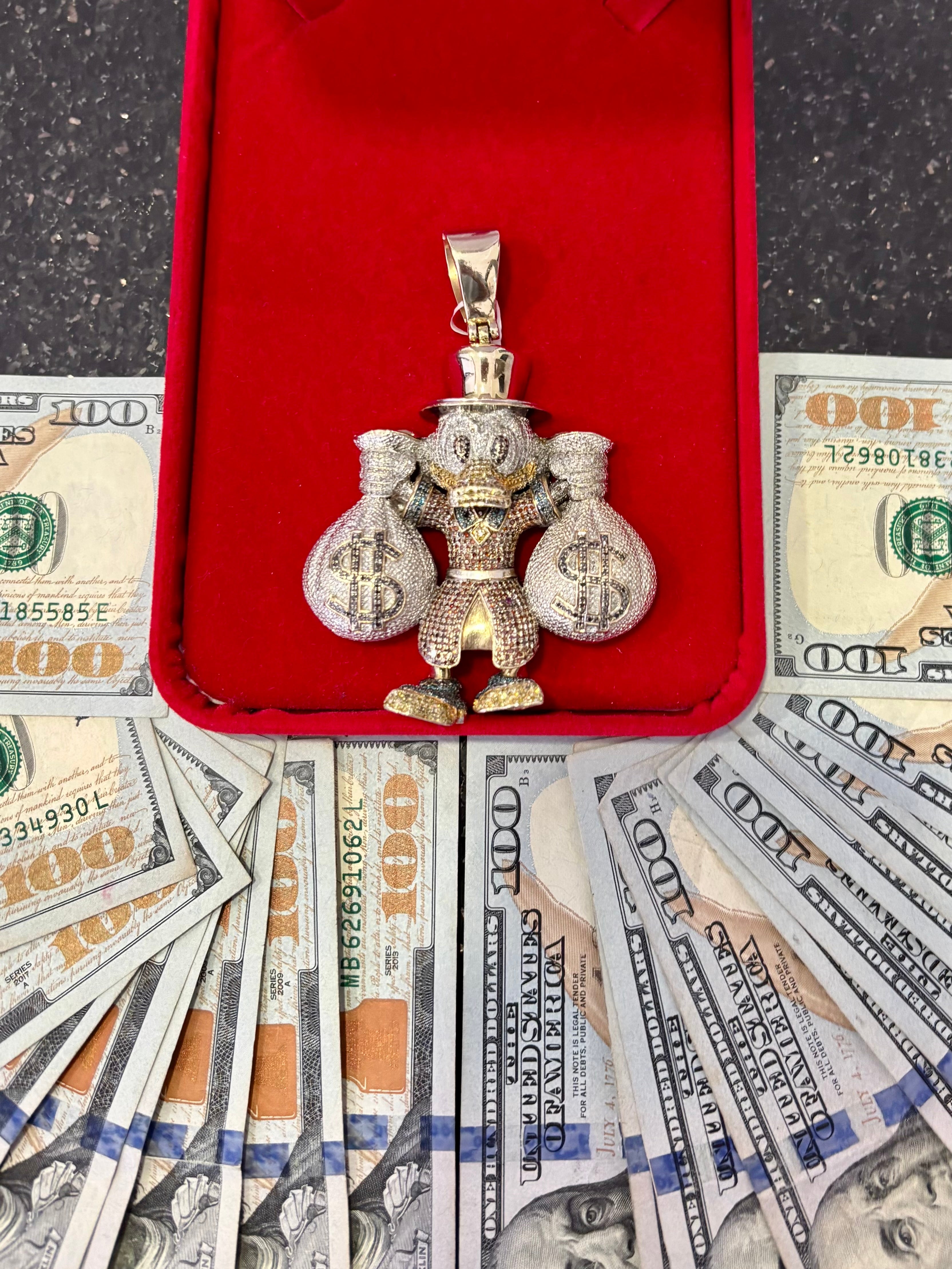 Money Duck Pendant Holding Bags of Money Surrounded By Cash
